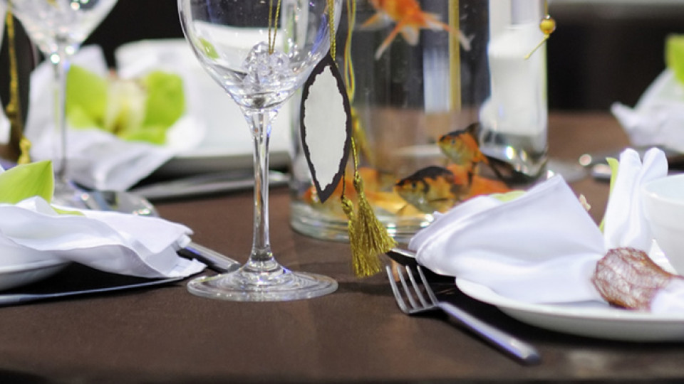 Verres, assiettes claires et éléments décoratifs sur une table dressée